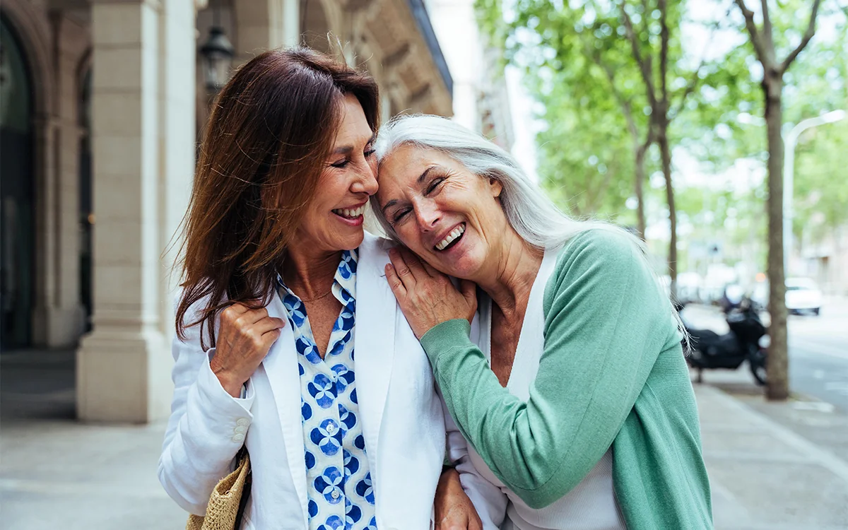 Two mature female friends laughing together
