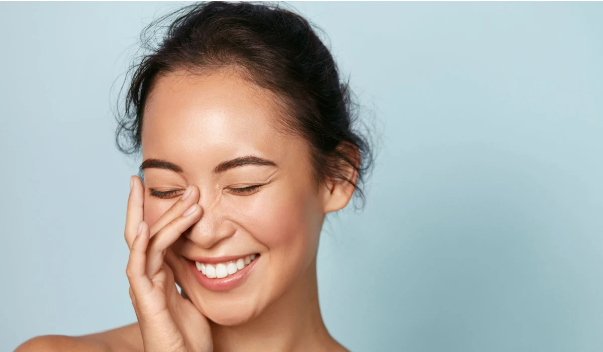 Beautiful happy girl model with fresh glowing hydrated facial skin