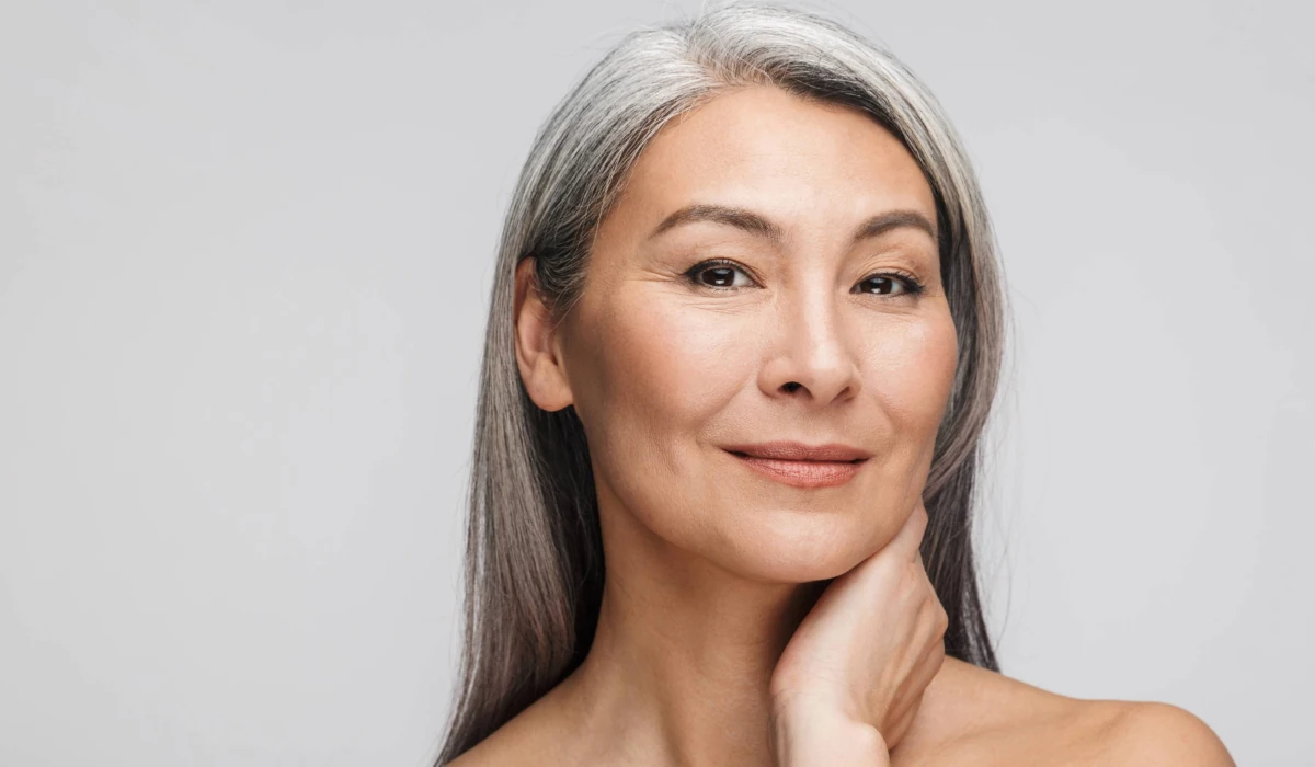 confident mature woman showing off tight skin around face and neck