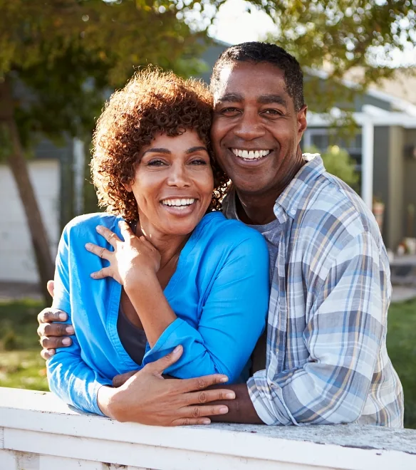 Woman with her husband standing outside their house