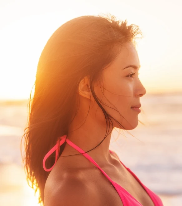 Young woman watching the sunset on the beach